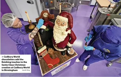  ?? Jacob King ?? Cadbury World chocolatie­rs add the finishing touches to the Santa Claus Christmas creation at Cadbury World in Birmingham