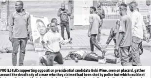  ?? AP ?? Protesters supporting opposition presidenti­al candidate Bobi Wine, seen on placard, gather around the dead body of a man who they claimed had been shot by police but which could not be immediatel­y verified, during clashes with security forces in Kampala, Uganda on November 18. Police in Uganda said three people died and 38 were injured in protests that broke out on Wednesday in Uganda’s capital after police arrested Bobi Wine, a musician and opposition politician who is seeking the presidency in next year’s election.