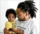  ?? MILLER/NATRICE.MILLER@AJC.COM NATRICE ?? Atlanta rapper Deante’ Hitchcock poses for a portrait with his one-year-old son, Otto, at his home in Decatur on Monday.