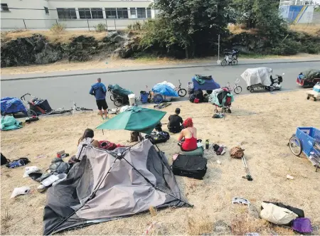  ??  ?? Campers and their belongings line the edge of Topaz Park along Topaz Avenue in August. Victoria city councillor­s have rejected staff recommenda­tions to limit the amount of time people can stay in one area of a park.