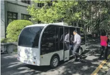  ?? Getty; AFP ?? Top, an Uber self-driving car travels down 5th Street in San Francisco, California. Above, passengers climb on board a selfdrivin­g minibus at Shanghai Jiao Tong University