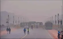  ??  ?? People walk near Raisina Hills on a cold, foggy morning, in New Delhi on Sunday