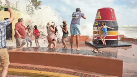  ?? ROB O’NEAL/AP ?? Visitors to the Southernmo­st Point buoy in Key West, Fla., brave the waves as the feeder bands of Hurricane Laura pass by the area on Monday.