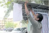  ??  ?? Sasikumar, 45, a car cleaner who lost his job during the lockdown, hangs a white flag to seek help from members of the public, outside his home in Kuala Lumpur.