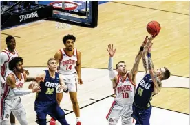  ?? ASSOCIATED PRESS ?? Oral Roberts’ Carlos Jurgens shoots over Ohio State’s Justin Ahrens in the first half Friday in the Buckeyes’ stunning defeat at the hands of 15th-seeded Oral Roberts at Mackey Arena in West Lafayette, Indiana.