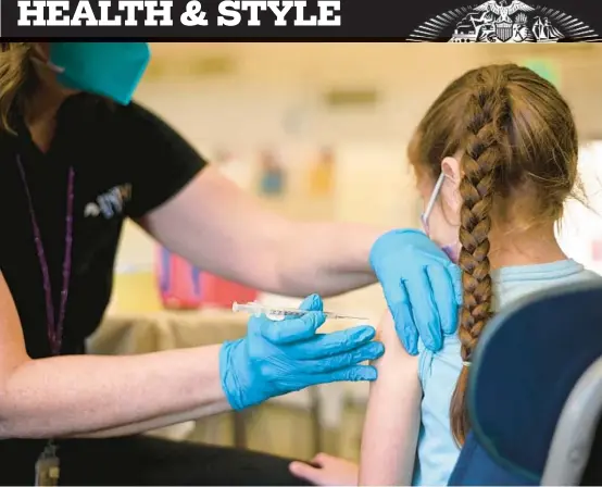  ?? ROBYN BECK/GETTY-AFP 2022 ?? A nurse administer­s a pediatric dose of the COVID-19 vaccine to a girl at a Los Angeles clinic.