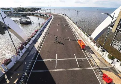  ?? ALLEX QOMARULLA/JAWA POS ?? TEROBOS JEMBATAN: Seorang pengendara sepeda melewati Jembatan Suroboyo yang masih ditutup kemarin.