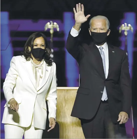  ?? ANDREW HARNIK — THE ASSOCIATED PRESS ?? President-elect Joe Biden, with Vice President-elect Kamala Harris, acknowledg­e drive-in viewers at the Chase Center in Wilmington, Del., on Saturday