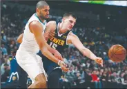  ?? AP/DAVID ZALUBOWSKI ?? Charlotte Hornets forward Nicolas Batum (left) fights for control of the ball with Denver Nuggets center Nikola Jokic on Saturday in Denver.