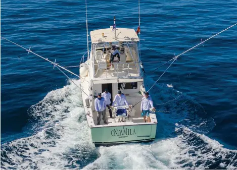  ??  ?? Capt. Marty Bates at the helm of his tough 38-foot Henriques charter boat, La Onda Mila, on the troll in Cape Verde.