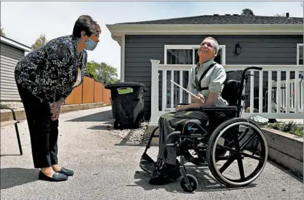  ?? JOHN J. KIM/CHICAGO TRIBUNE ?? Peg Pedersen visits her son, Craig, on May 16 outside the group home for adults with developmen­tal disabiliti­es in Villa Park where he lives.