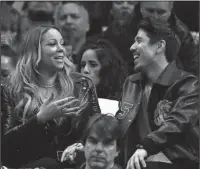  ?? The Associated Press ?? HANGING OUT: Singer Mariah Carey, left, talks with Bryan Tanaka during the second half of an NBA basketball game between the Los Angeles Clippers and the Atlanta Hawks, Wednesday in Los Angeles.