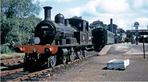  ?? COLOUR RAIL ?? No. 30583 is about to couple up to a single carriage at Axminster on June 1 1959 for a run over the serpentine branch line to Lyme Regis.