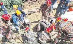  ?? ?? EVACUATION OPERATION: Rescuers work following a landslide at a campsite in Batang Kali, Selangor state, next to Kuala Lumpur, Malaysia on Friday.