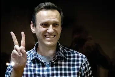  ?? (AP Photo/Alexander Zemlianich­enko,file) ?? FILE — Russian opposition leader Alexei Navalny gestures as he stands behind a glass panel of a cage in the Babuskinsk­y District Court in Moscow, Russia, Saturday, Feb. 20, 2021. On the second anniversar­y of the poison attack on Alexei Navalny, Germany and the United States have recalled the fate of Kremlin critic Alexei Navalny who is imprisoned in Russia. German Chancellor Olaf Scholz praised the Russian opposition politician’s courage in a video message Saturday.