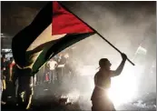  ?? ARASH KHAMOOSHI — THE NEW YORK TIMES ?? A man flies the Palestinia­n flag amid celebratio­ns of support in Tehran, Iran for the Hamas attacks on Oct. 7.