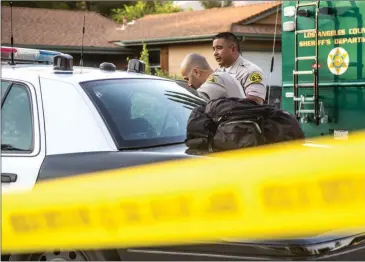  ?? Austin Dave/The Signal (See additional photos at signalscv.com) ?? Santa Clarita Valley Sheriff’s Station deputies speak to an unknown suspect seated in the back of a patrol car on the 29200 block of Abelia Road in Santa Clarita. The preliminar­y hearing of Nicholas Colletta and Jacqueline Arreola began on Monday in...