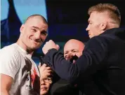  ?? ?? Sean Strickland, left, UFC middleweig­ht champion, and Dricus Du Plessis, right, face off after holding a mixed martial arts news conference Thursday ahead of UFC 297 in Toronto.
