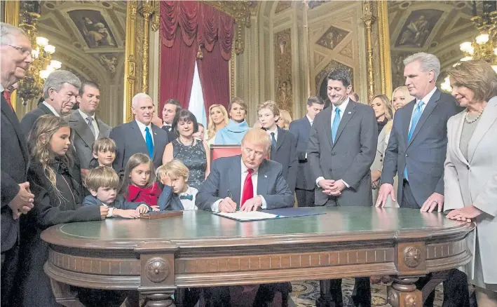  ?? REUTERS ?? Primer acto. En familia,Trump firmó un puñado de decretos y órdenes ejecutivas, entre ellas, una que reduce el alcance del programa de salud creado por su antecesor, Obama.