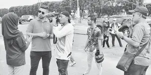  ??  ?? RAKAMAN: Hos travelog Warna Warni Asia, Nik Michael (kiri) bersama jurukamera sambil dipantau oleh Yusmal (kanan) sedang menemu bual peserta antarabang­sa BIKF 2018.