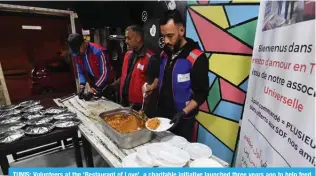  ?? — AFP ?? TUNIS: Volunteers at the ‘Restaurant of Love’, a charitable initiative launched three years ago to help feed the growing number of Tunis’ homeless, work in the kitchen of the NGO, in Tunis.