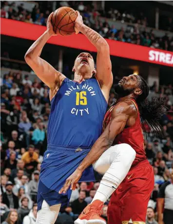  ?? David Zalubowski / Associated Press ?? Nuggets center Nikola Jokic, left, has his way with former teammate Kenneth Faried and the defenseles­s Rockets on Friday night. Jokic finished with 31 points, 13 rebounds and nine assists.