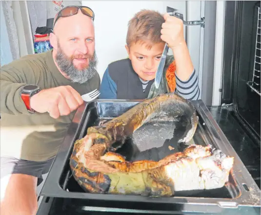  ?? PHOTO / BEVAN CONLEY ?? Chris Friedel and Maihi Brown tuck into some eel at the Whanganui High School Matariki Ha¯ngi.