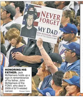  ?? Robert Sabo ?? HONORING HIS FATHER: Jack McNamara holds up a sign in remembranc­e of his father, John McNamara of the FDNY, who died in 2009 of 9/11-related cancer.