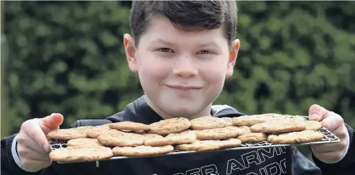  ?? PHOTO: PETER MCINTOSH ?? Baking it better . . . Charlie Stevenson, of Dunedin, holds a tray of his freshly baked chocolate chip biscuits, which he is selling to raise funds for Starship Children’s Hospital.