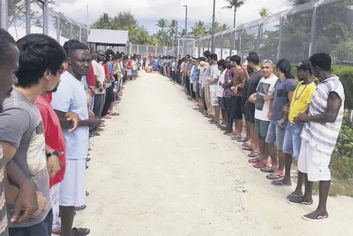  ??  ?? Refugees links hands in solidarity ahead of the center’s closure at the Manus Island detention center, Papua New Guinea, Oct. 31.