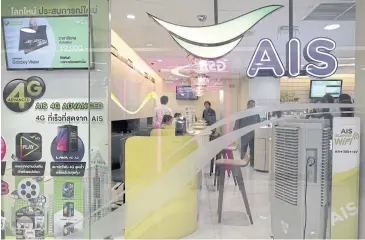  ?? REUTERS ?? Customers wait for service at an AIS shop in Bangkok.