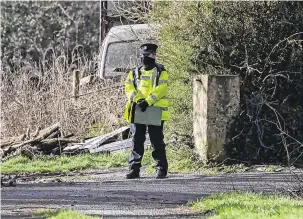  ?? PHOTO: DARAGH McSWEENEY ?? Tragedy: A garda at the farm just outside Mitchelsto­wn, Co Cork, where two of the bodies were found yesterday. Brothers Paddy (top left) and Willie Hennessy (above left).