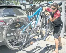  ??  ?? Mounting her mountain bike on a car rack, Furtado gets ready to go for a ride. The bicycle comes from her store, Juliana Bicycles, in Santa Cruz.