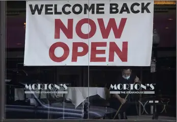  ?? JEFF CHIU — THE ASSOCIATED PRESS FILE ?? A sign reading “Welcome Back Now Open” is posted on the window of a Morton’s Steakhouse in San Francisco.