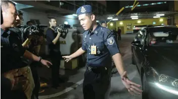  ?? — AFP ?? A Malaysian policeman tries to stop members of the media as a North Korean embassy official leaves the forensic department where the body of a North Korean man suspected to be Kim Jong-Nam is being kept at the Hospital Kuala Lumpur on Wednesday.