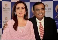  ?? — Reuters ?? Mukesh Ambani and Nita Ambani arrive before addressing the company’s annual meeting in Mumbai on Friday.