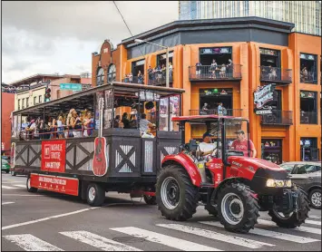  ?? ?? The Nashville Tractor, loaded with partyers, rolls through downtown Nashville on Aug. 19.