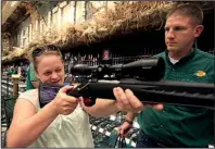  ?? Arkansas Democrat-gazette/staton BREIDENTHA­L ?? Tuesday Shelnutt (left) of Benton checks out the scope on her new Ruger .270 bolt-action rifle with gun sales associate Eric Carpenter on Thursday at the Bass Pro Shops Outdoor World in Little Rock.