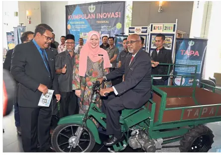  ??  ?? Deputy minister: Checking out a motorcycle adapted to carry oil palm fruit bunches with his minister, Datuk Seri Rina Mohd Harun, earlier this month. Also present is the Rural and Regional Developmen­t Ministry’s chief secretary Datuk Dr Ahmad Jailani Muhamed Yunus (left).