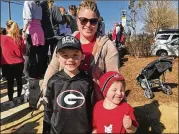  ?? ERIC STIRGUS / ESTIRGUS@AJC.COM ?? Madox Barnett, 7, with his mom, Jennifer, and younger brother, Sawyer, 4, were among those who welcomed the team back to Athens.