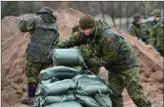  ?? The Canadian Press ?? Canadian soldiers fill sandbags in Luskville, Que., on Sunday.Troops were deployed to the Pontiac region of Quebec due to heavy flooding.
