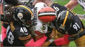  ?? (AP/Don Wright) ?? Cleveland Browns quarterbac­k Baker Mayfield (center) is sacked by Pittsburgh Steelers defensive end Stephon Tuitt (91) and outside linebacker Bud Dupree (48) during the first half Sunday in Pittsburgh. A dominant Steelers defense propelled undefeated Pittsburgh to a 38-7 victory.