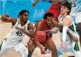  ?? Michael Conroy / Associated Press ?? Houston forward Justin Gorham, center, loses the ball between Baylor guards Davion Mitchell (45) and Matthew Mayer in the first half of the Final Four game.