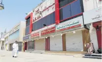  ?? PHOTO: REUTERS ?? All shut . . . A man walks next to closed shops in Riyadh, Saudi Arabia.