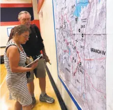  ?? Melody Gutierrez / The Chronicle ?? Laura and Wayne Rathe look at a map of the Carr Fire after a community meeting in Redding. The couple lost their home.