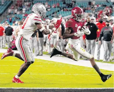  ?? CHRIS O’MEARA/AP ?? Alabama wide receiver DeVonta Smith scores a touchdown past Ohio State safety Josh Proctor during the College Football Playoff national championsh­ip game on Jan. 11 in Miami Gardens.