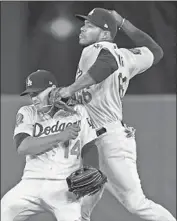  ??  ?? YASIEL PUIG has to deal with Enrique Hernandez as he makes a throw in the seventh inning.