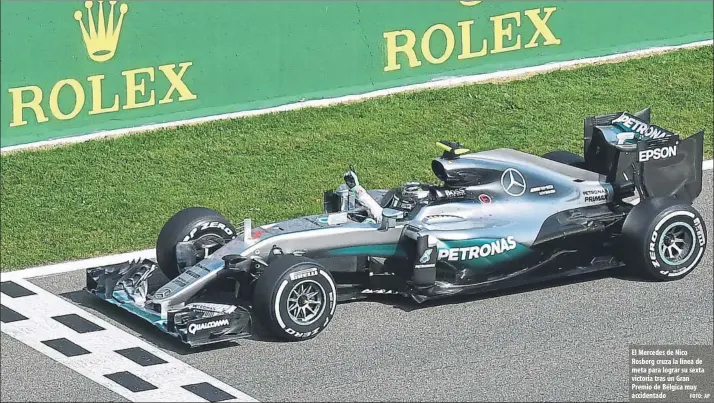  ?? FOTO: AP ?? El Mercedes de Nico Rosberg cruza la línea de meta para lograr su sexta victoria tras un Gran Premio de Bélgica muy accidentad­o