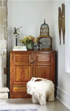  ??  ?? |BOTTOM RIGHT| CHARACTER PIECES. A vintage bird cage, a collection of animal figurines and a stack of old books add subtle charm atop the hutch. Most of the furniture comes from thrift stores or as hand-me-downs, including this wooden hutch. It also happens to be where the family hides their microwave.