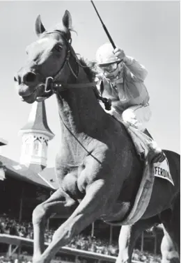  ?? JOHN SWART/AP ?? Jockey Bill Shoemaker raises his whip as he rides his mount Ferdinand to win the Kentucky Derby on May 3, 1986 at Churchill Downs. It was the fourth Derby win for Shoemaker.